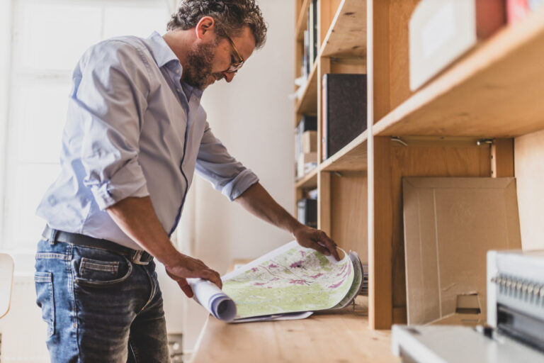 Thomas Büttner blickt auf eine Landkarte.