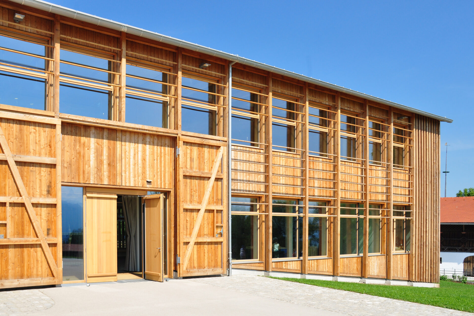 Eingang zum Freilichtmuseum Glentleiten, gebaut von Florian Nagler. Holz-Glas Fassade mit großem Tor.